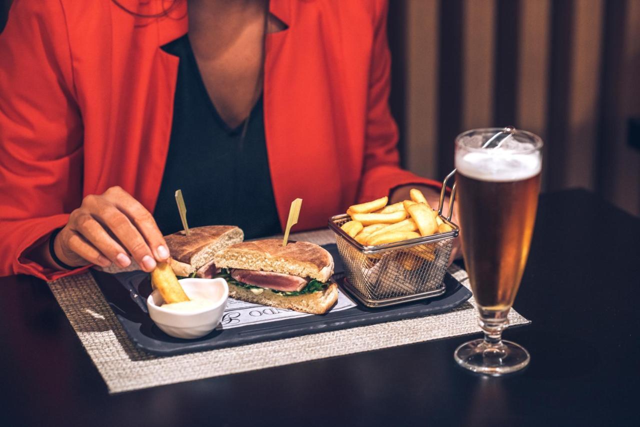 فندق إيبيروستار سيلكشين لشبونة Lisboa المظهر الخارجي الصورة A woman eating a hamburger and chips